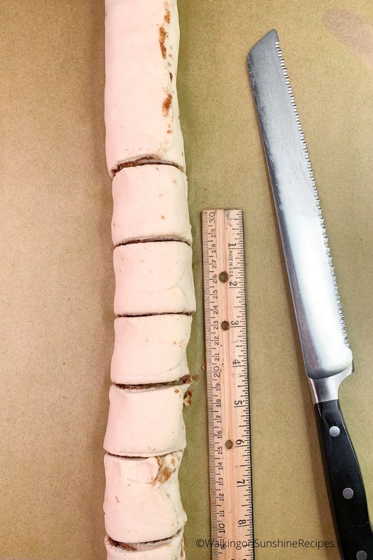 cinnamon rolls sliced with ruler and knife. 