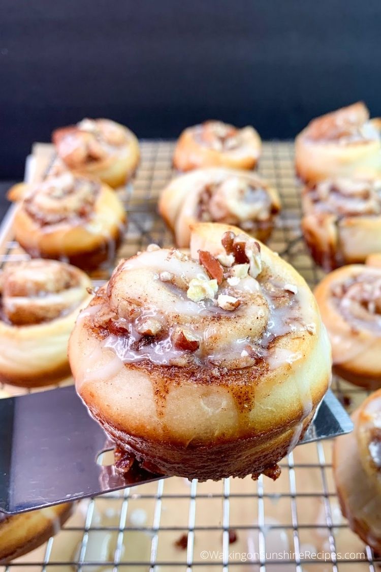 closeup of cinnamon roll with pecans and glaze. 