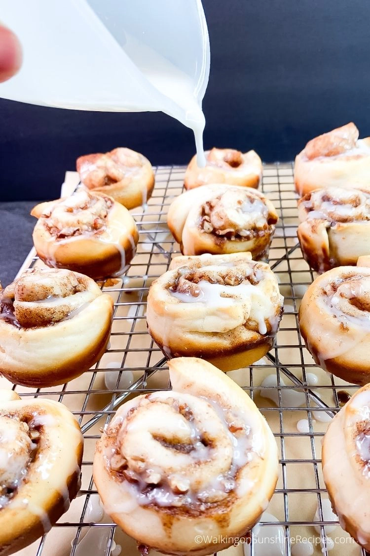 glaze being poured on top of cinnamon rolls with refrigerator biscuits. 