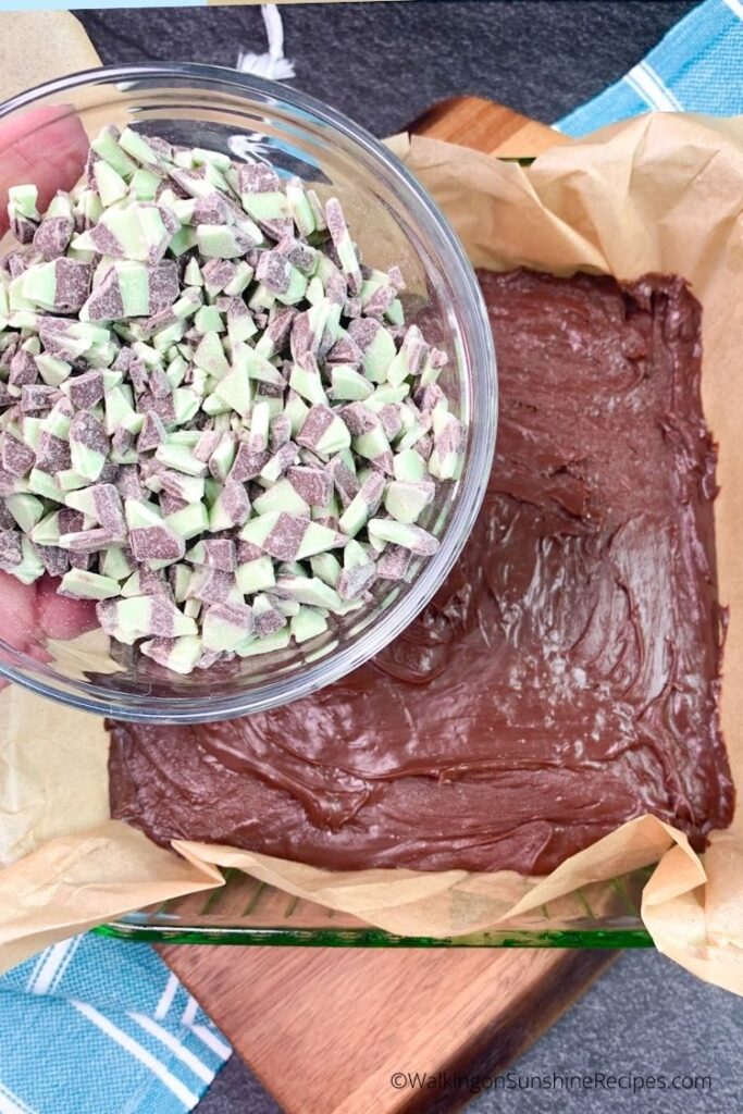 chocolate fudge in baking dish with mint baking chips in bowl.