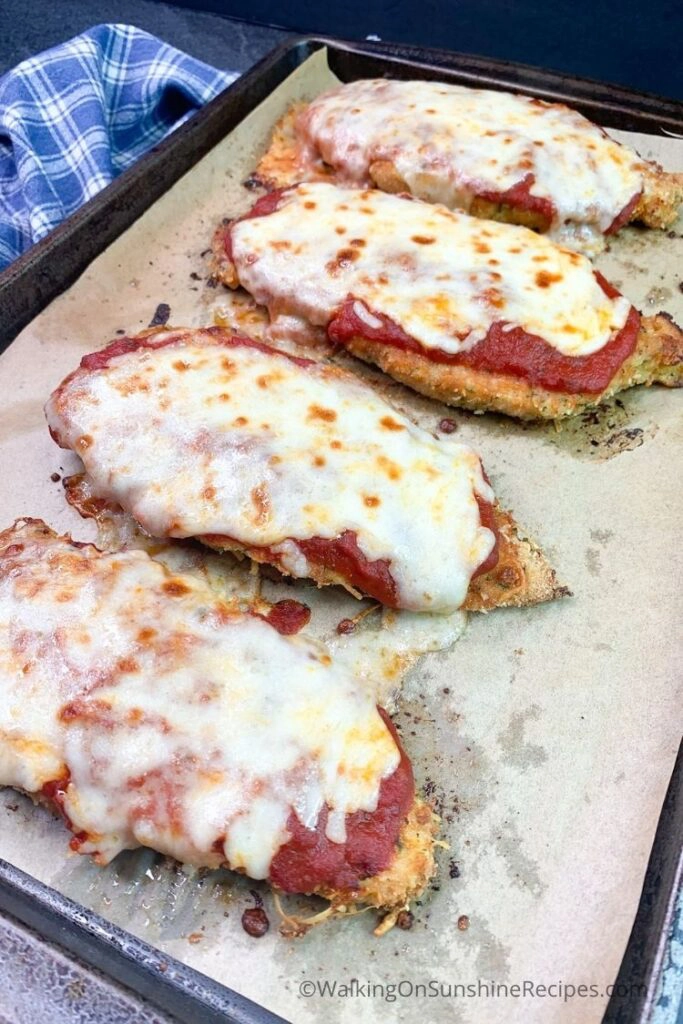 baked chicken cutlets on sheet pan with cheese. 