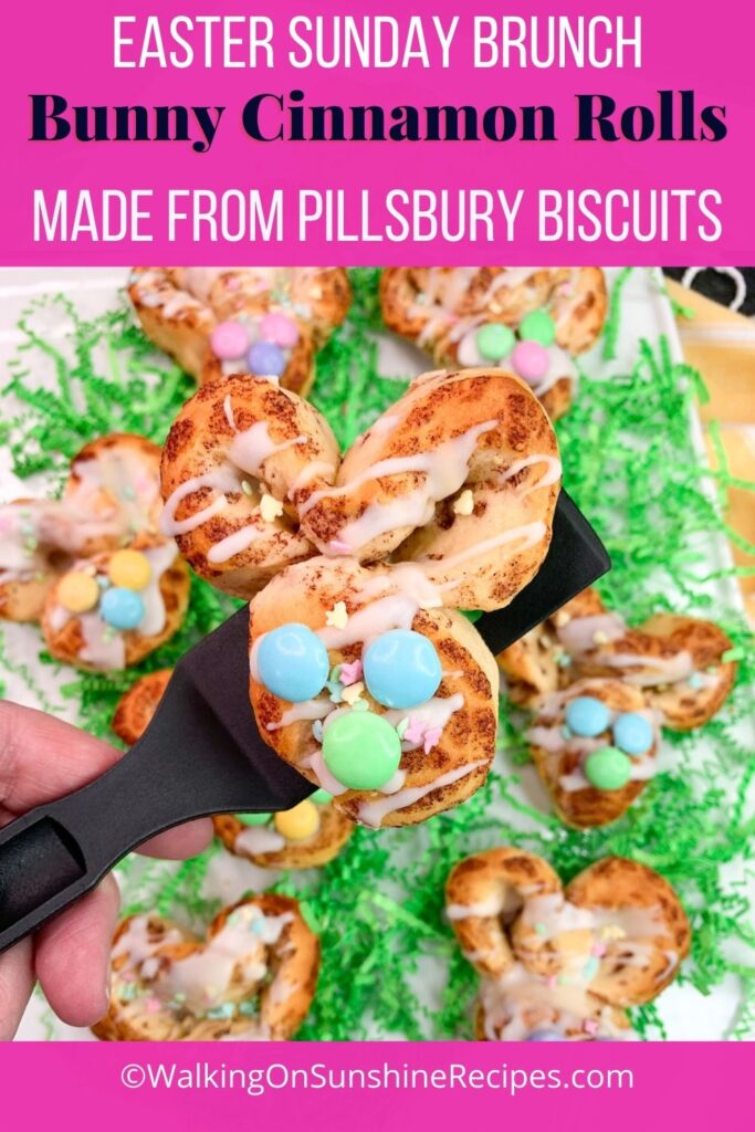 bunny shaped cinnamon roll with M&M candy pieces for eyes and nose.