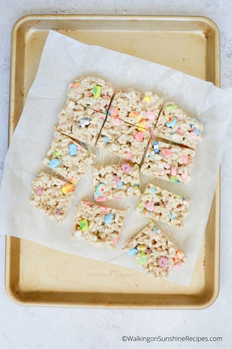 Marshmallow cereal bars on parchment paper in baking tray.