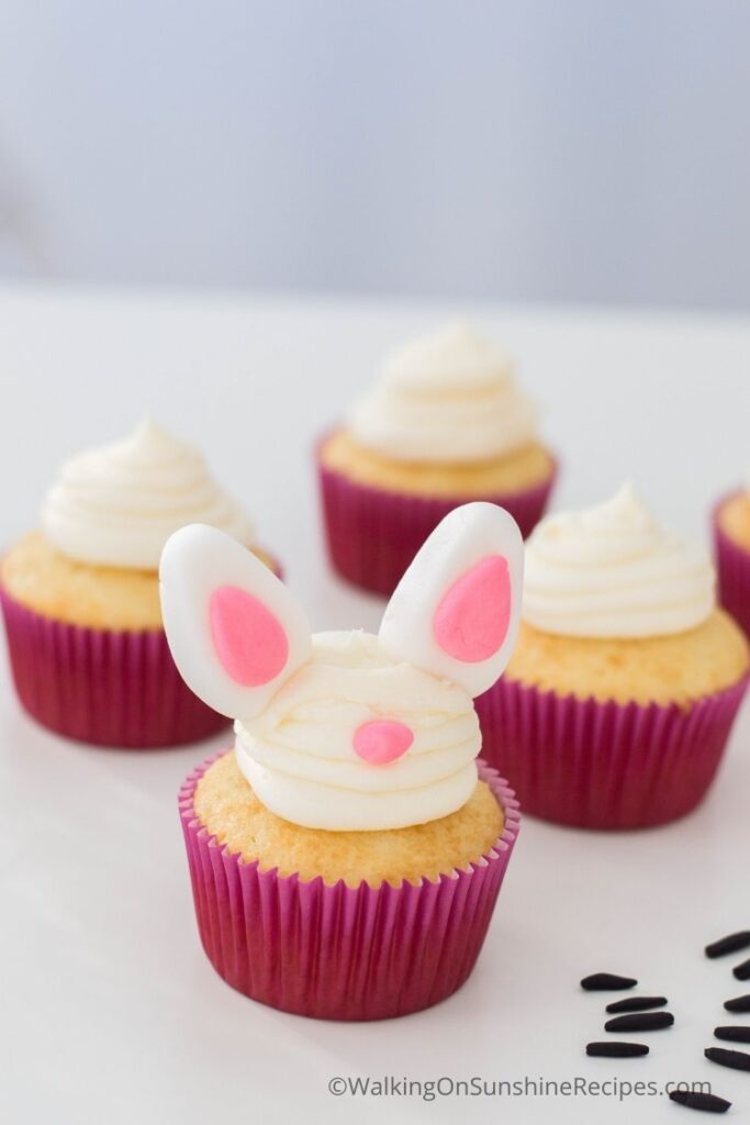 Add the fondant bunny ears to the vanilla cake mix cupcakes.