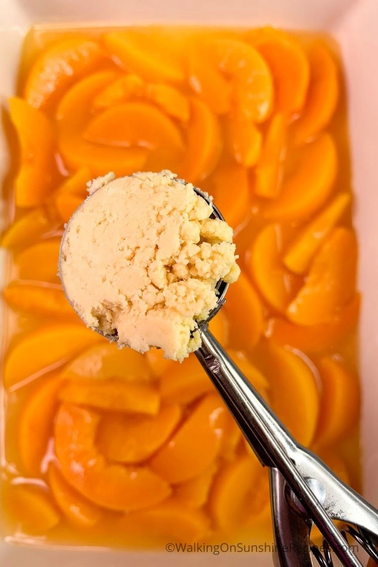 Cookie scoop with cake mix crumb topping over canned peaches. 