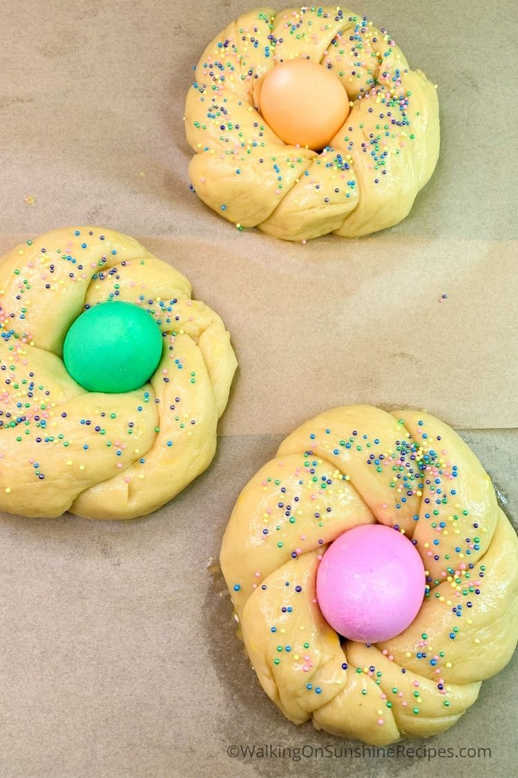 Colored sprinkles with Easter egg bread dough rings. 