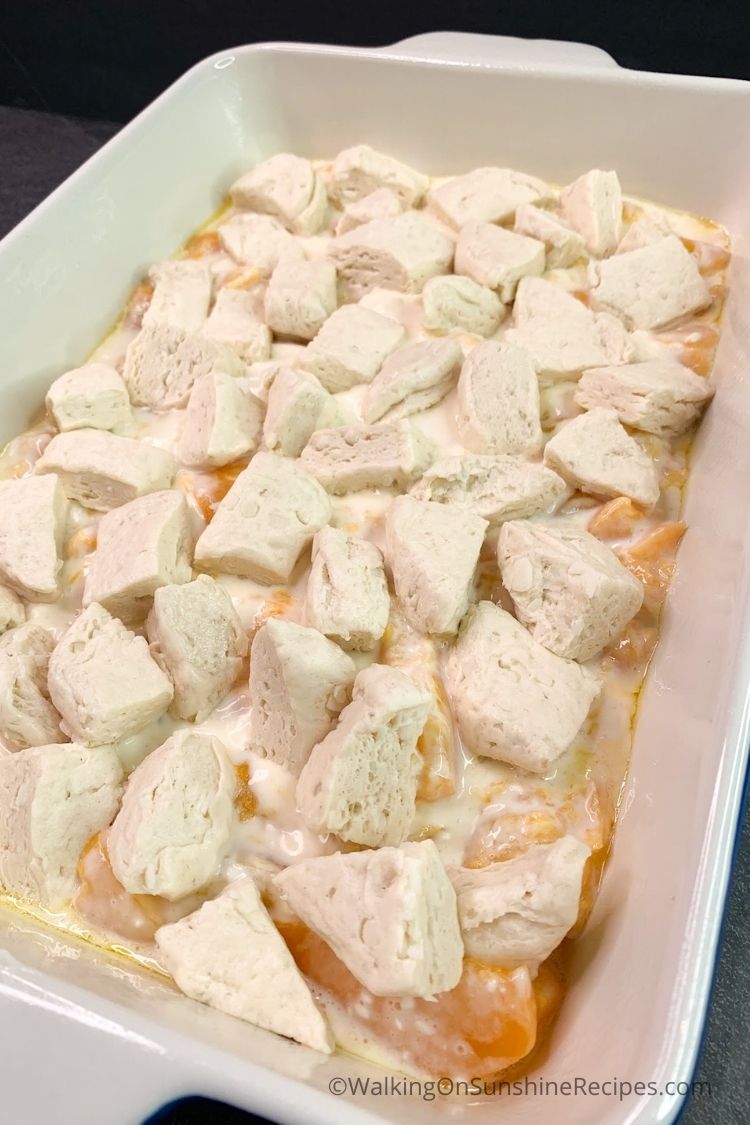cut up biscuits on top of peaches and cream cheese mixture. 