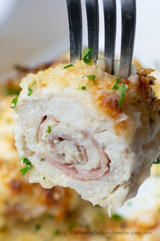 sliced open chicken cutlet stuffed with cheese and ham. 