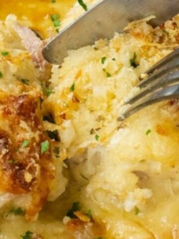 A knife and fork are cutting into the chicken.