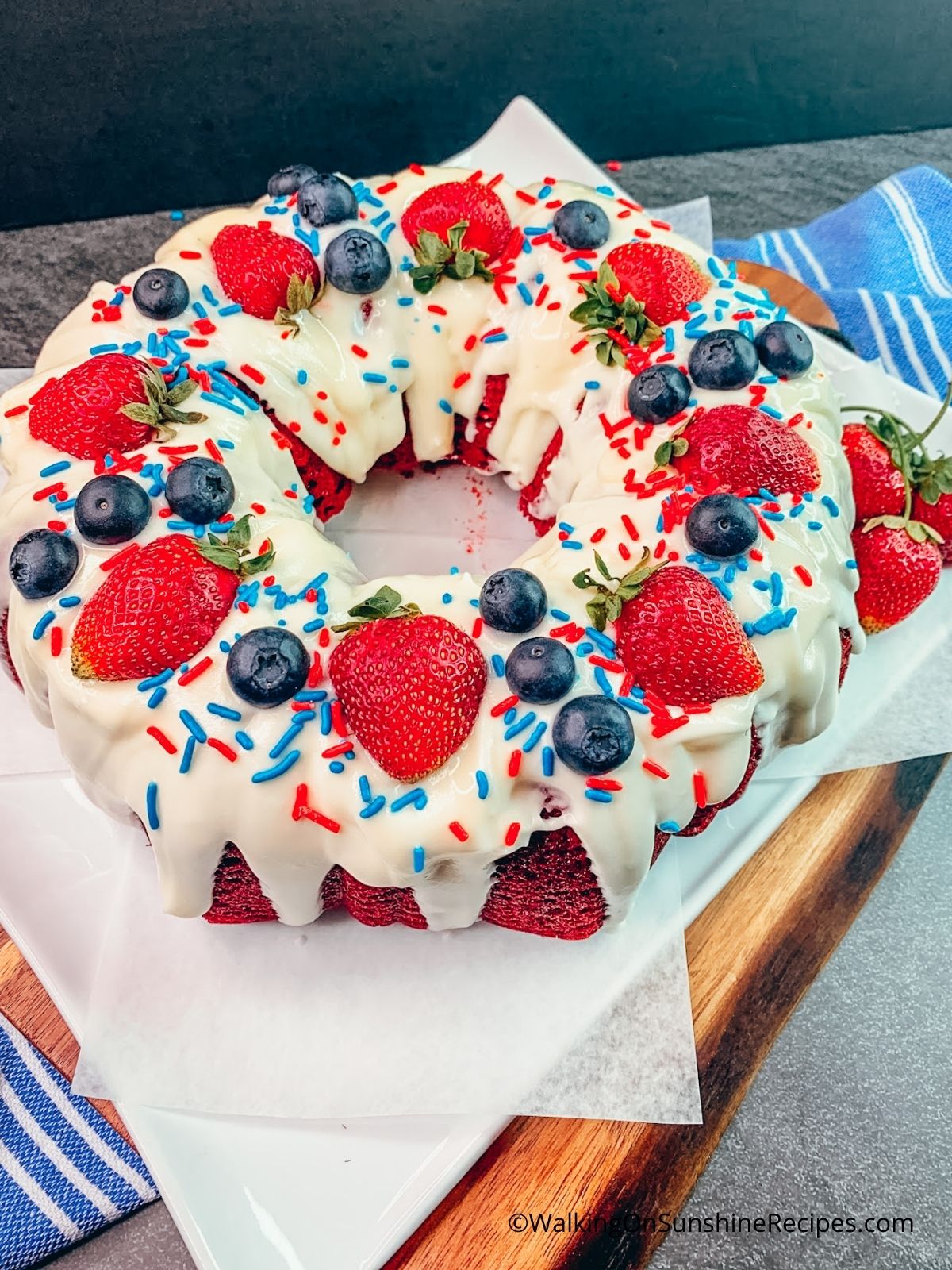 Add festive colored sprinkles to the top of the red velvet bundt cake from a cake mix.