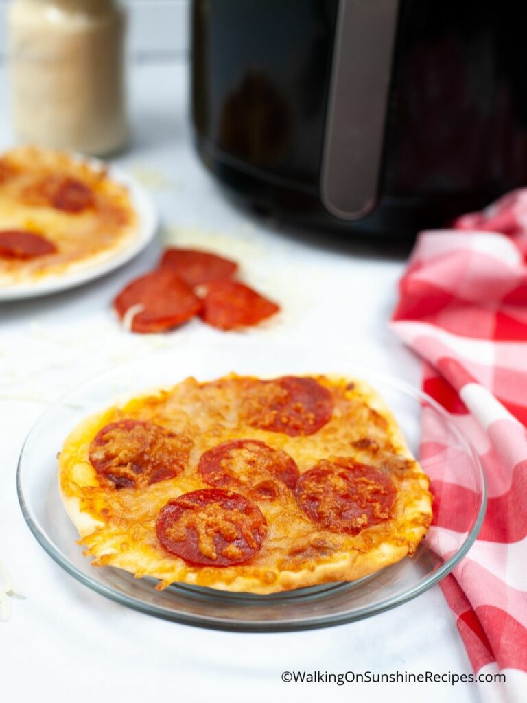Air Fryer pizza on tray with red cloth.