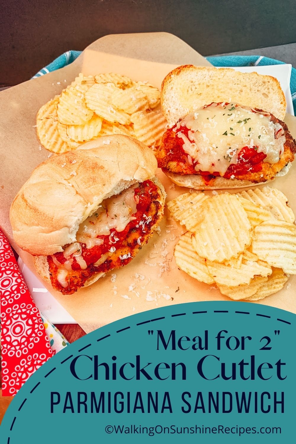 two chicken Parmigiana sandwiches on platter with potato chips.