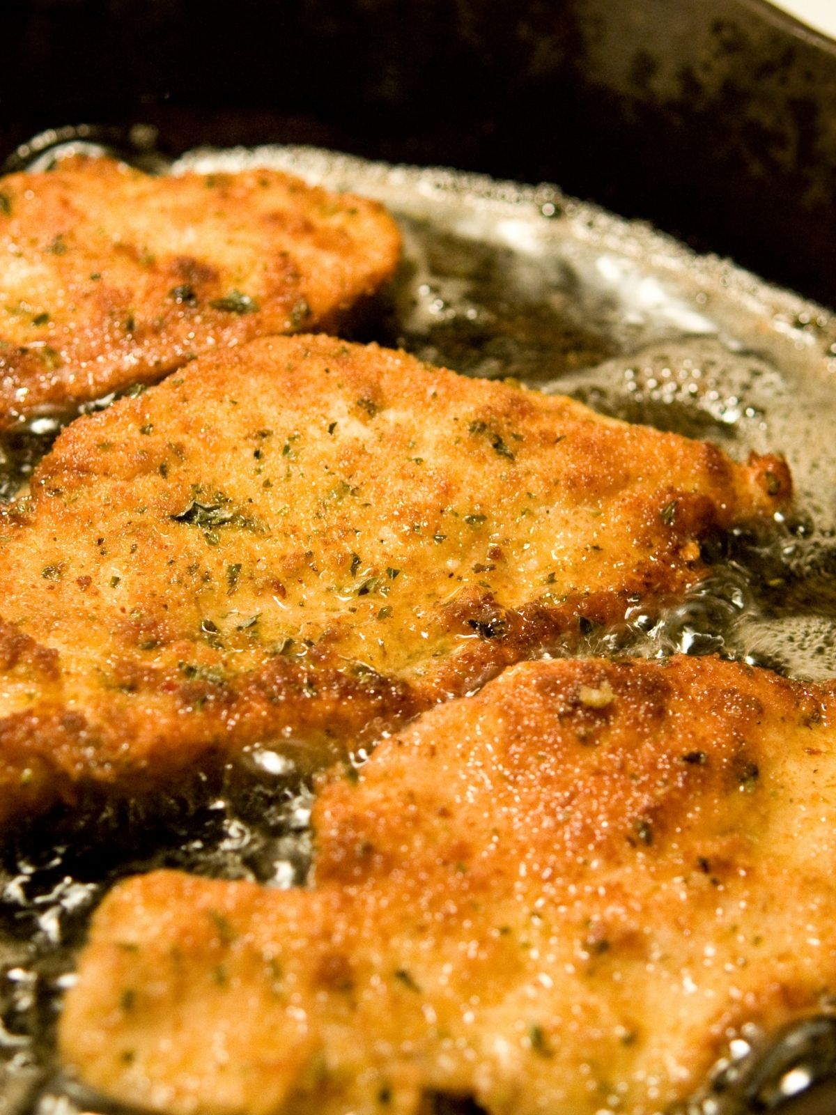  Italian Fried Chicken cutlets in frying pan.