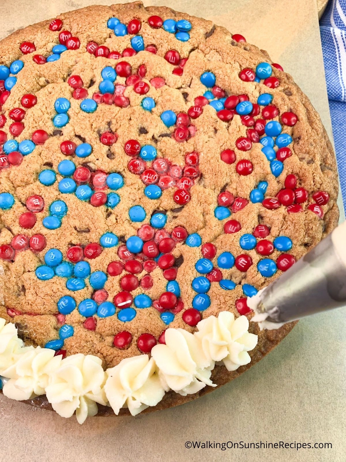 Piping Buttercream Icing around Giant Cookie.