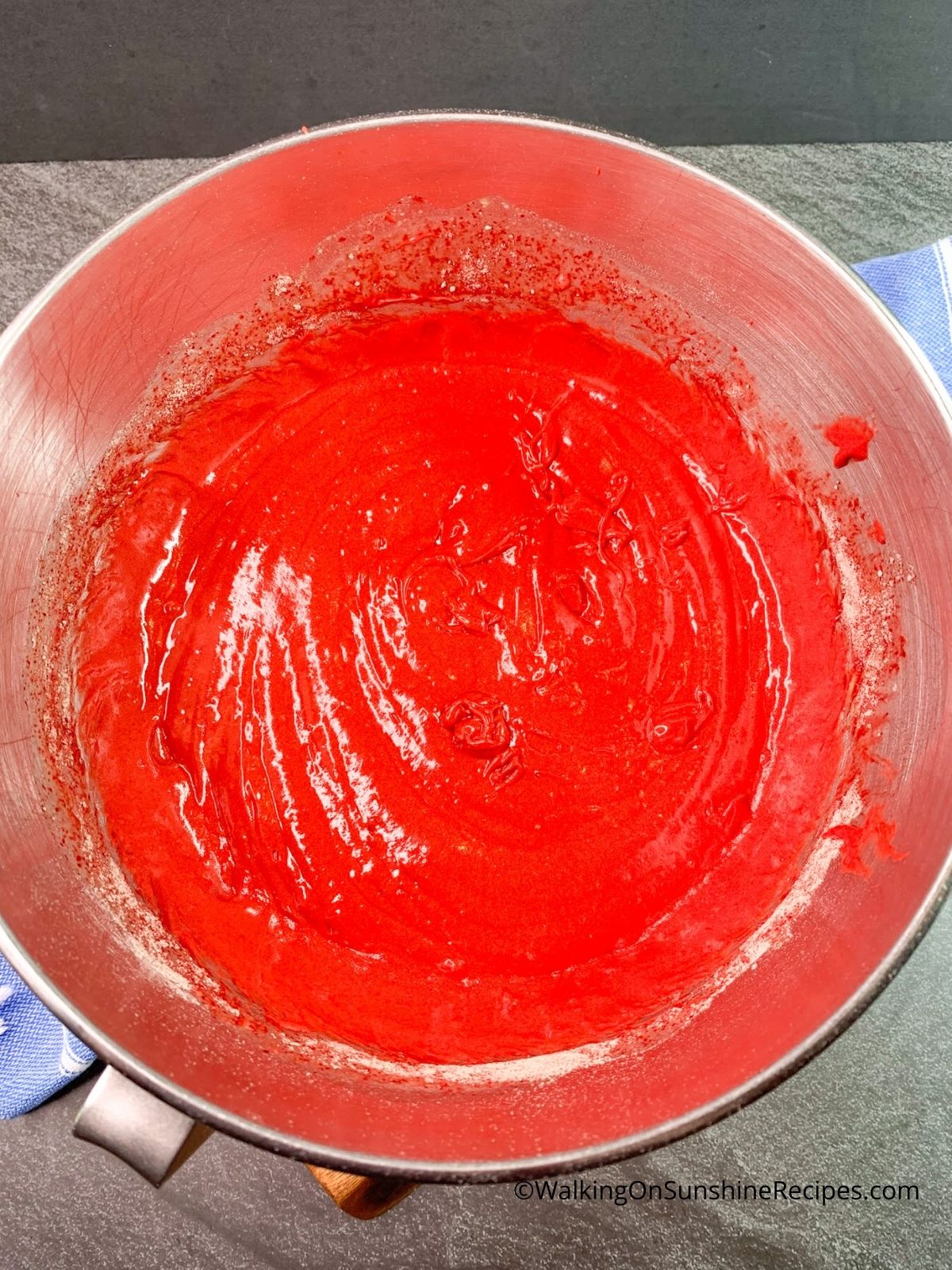 Red velvet cake completely blended in mixing bowl.