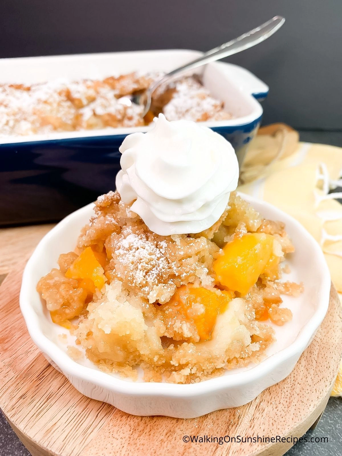 how to serve peach cobbler with whipped cream in small white bowl.