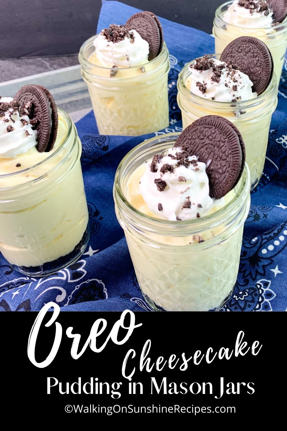 Oreo Cheesecake Pudding in mason jars with whipped cream and an Oreo cookie on top.
