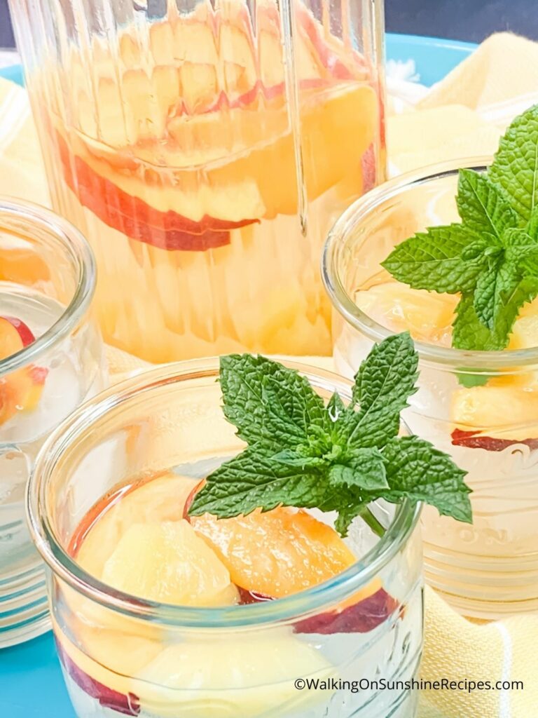 Coconut Infused Water in pitcher with two glasses and mint.