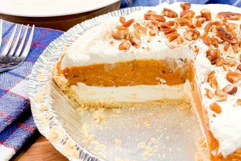 Pumpkin Cheesecake cut showing a white cheesecake layer and an orange pumpkin layer on top.