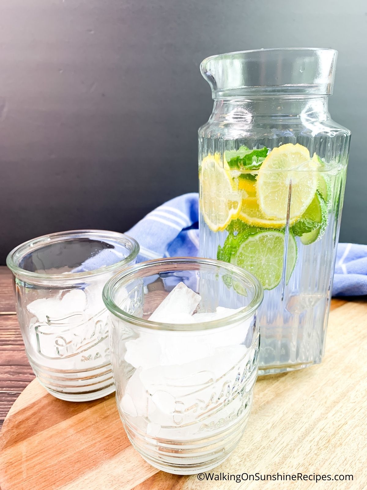 glasses with ice cubes and pitcher of lemon lime water. 