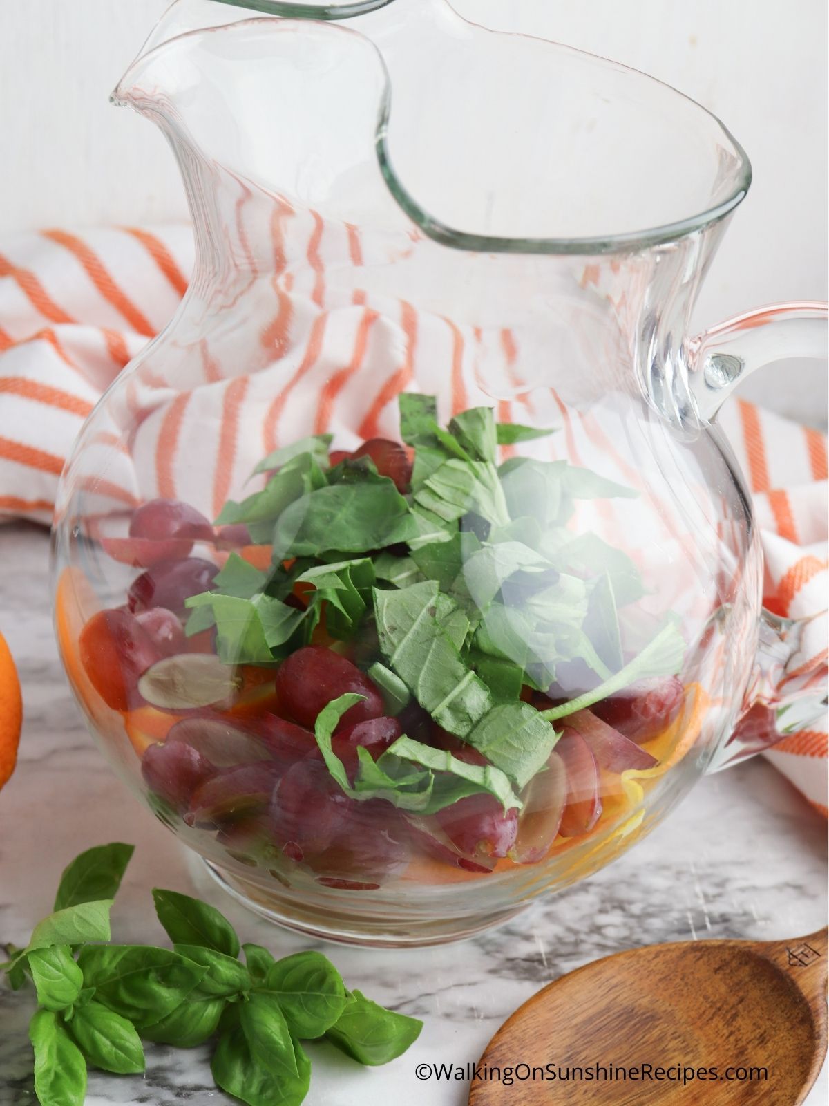 Add fruit, basil to pitcher.