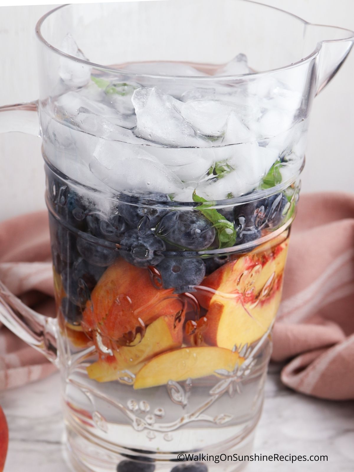 Add ice and water to pitcher with fruit.