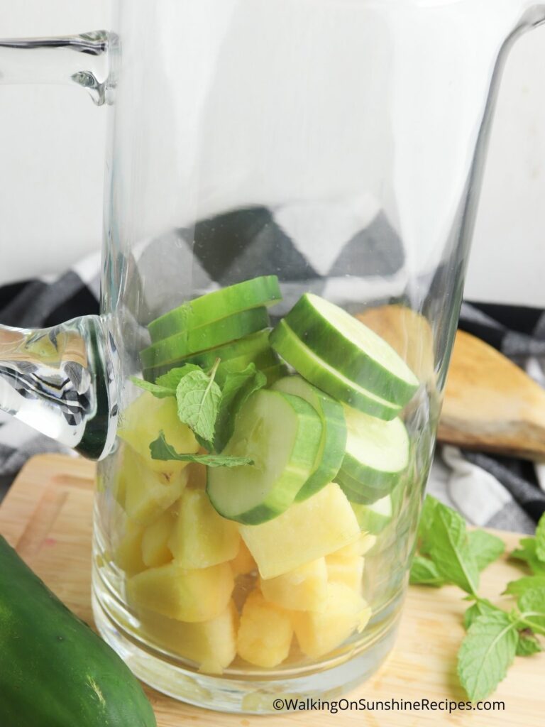 Add pineapple and cucumber to pitcher.