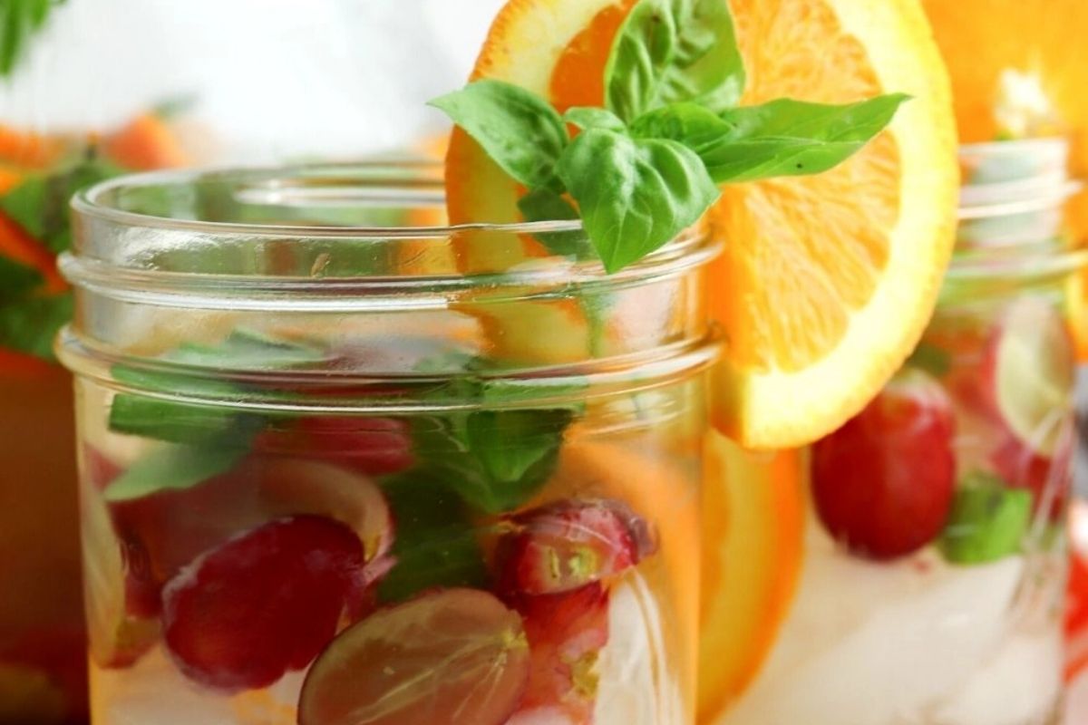 Clear water with floating grapes and mint.