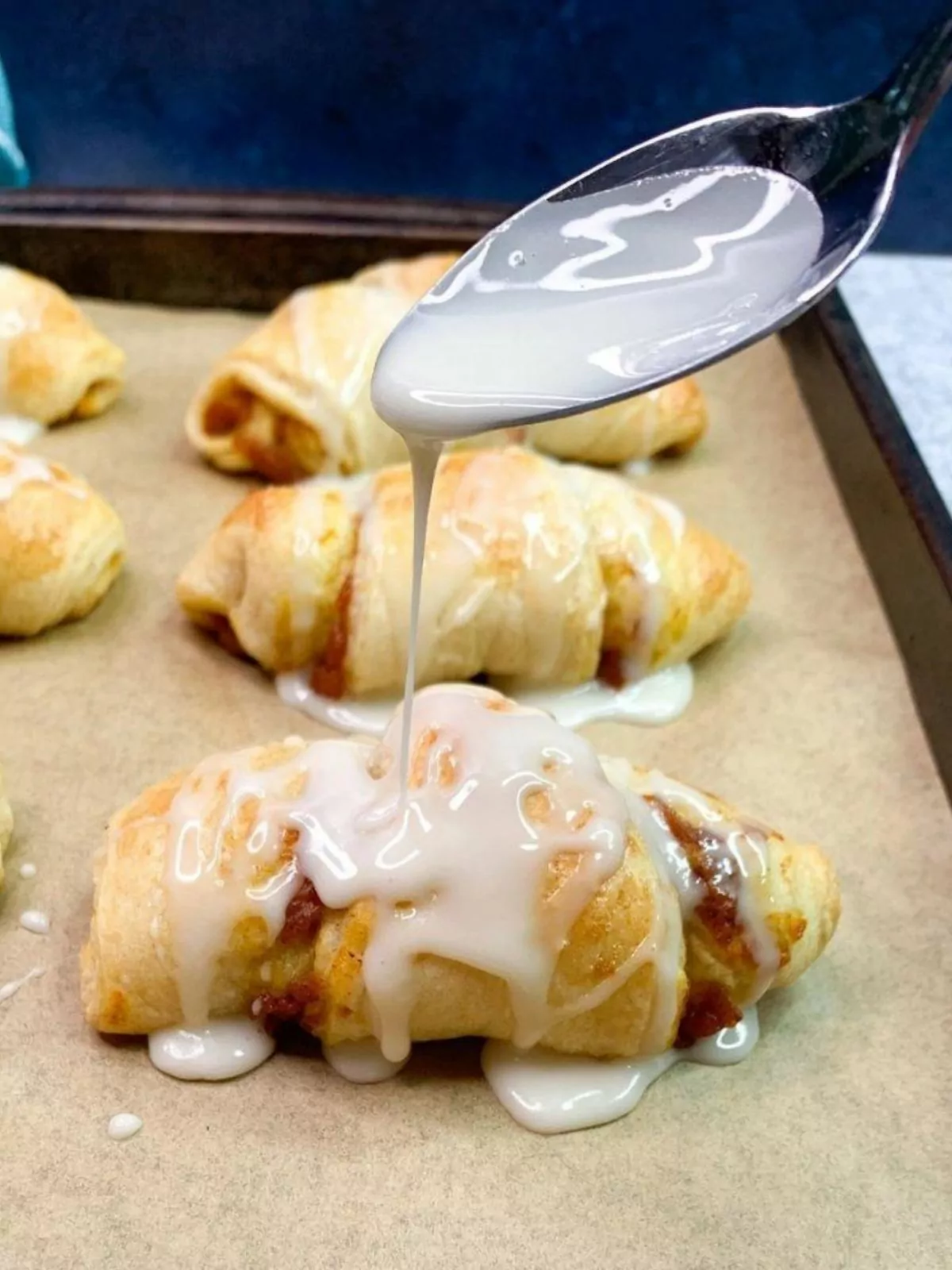 Glaze being added to the pumpkin pie crescents