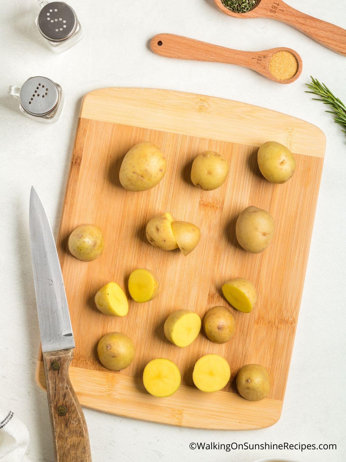 Cut potatoes in half on cutting board.
