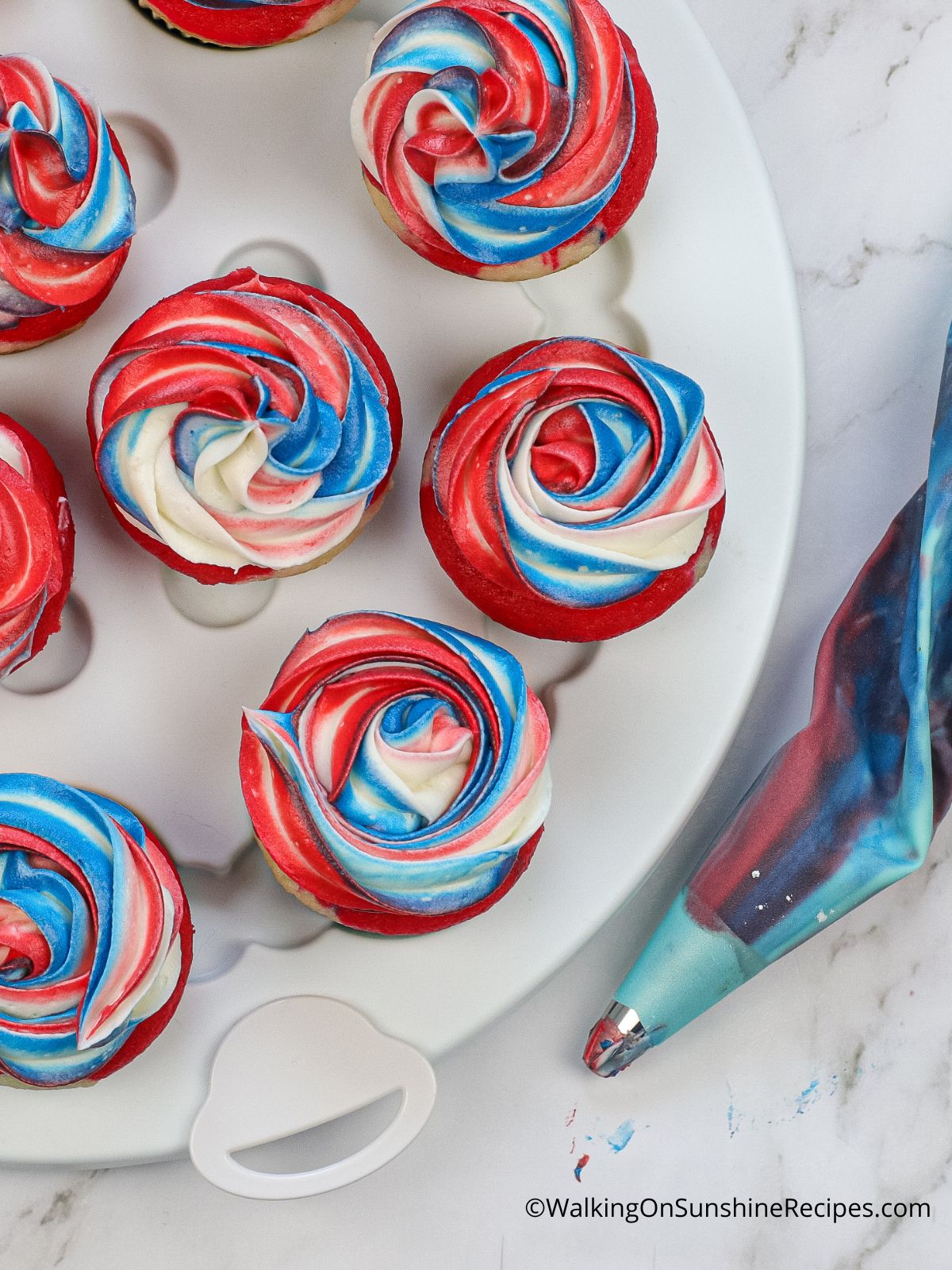 red, white and blue cupcakes with frosting. 