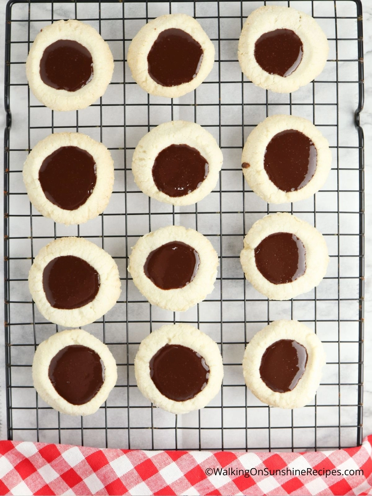 Fill the shortbread thumbprints with the melted chocolate ganache.