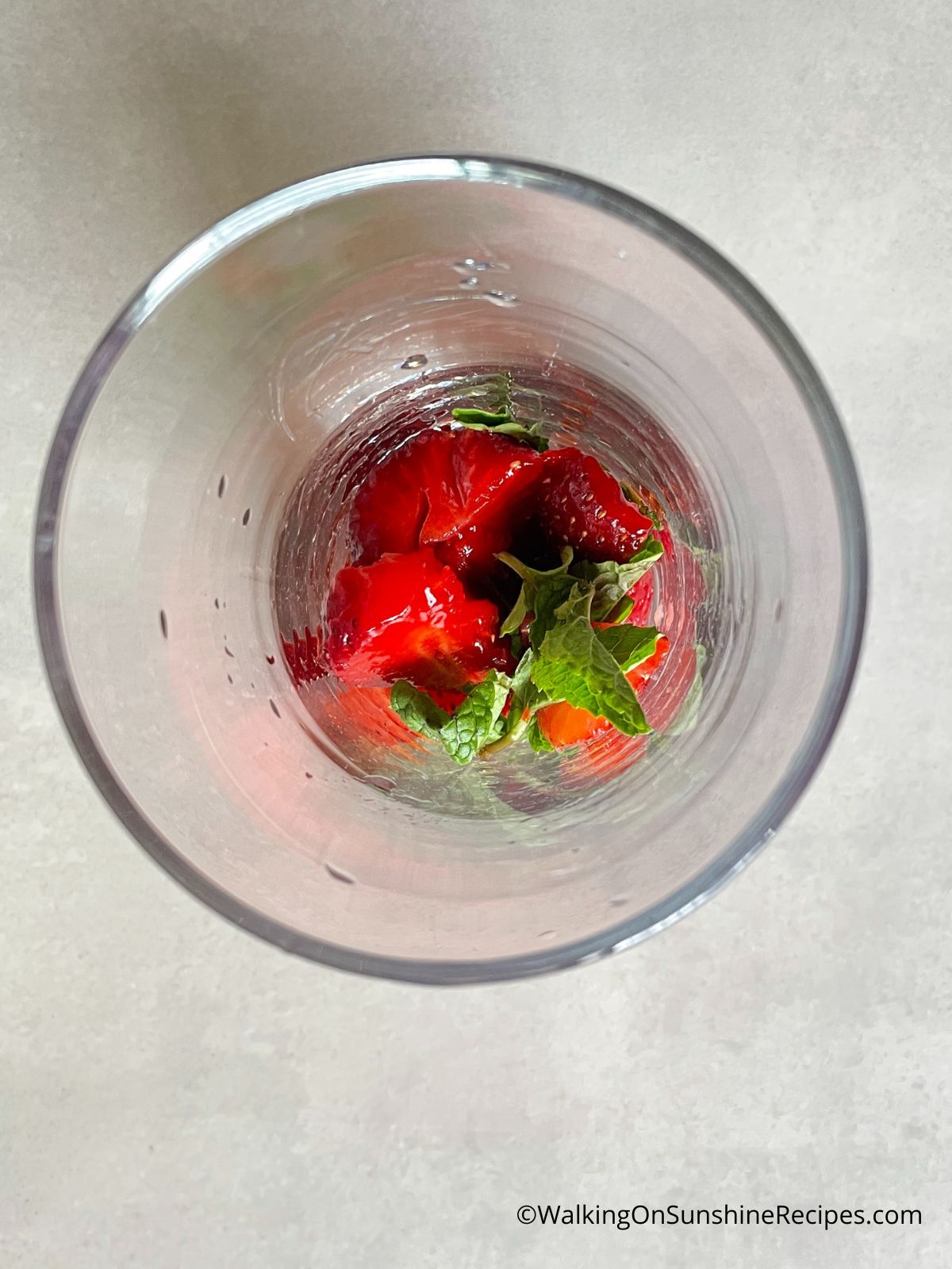 Add strawberries and mint to pitcher.