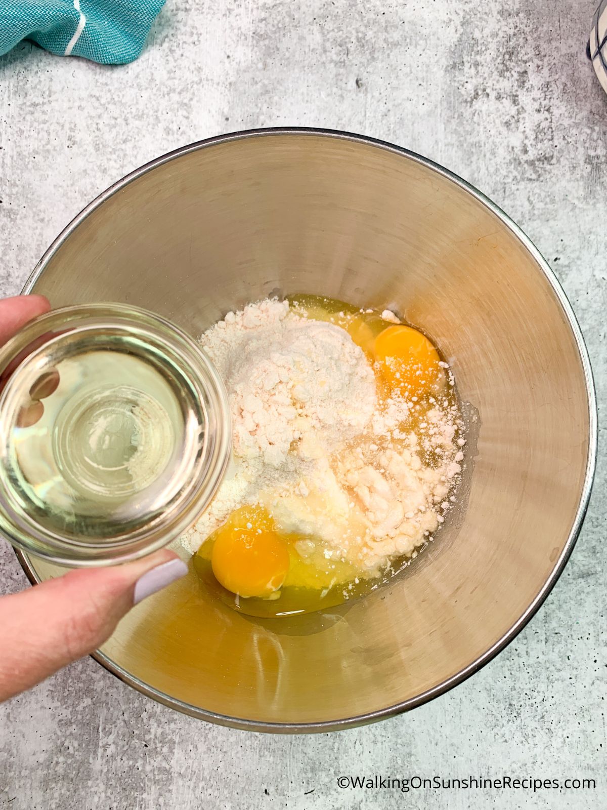 Vegetable oil in bowl with eggs and vanilla cake mix.