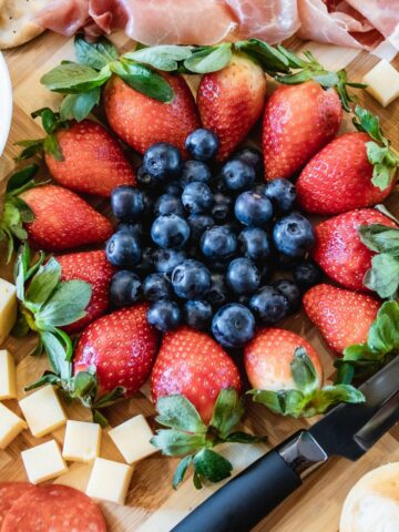 blueberries, strawberries and cheese for patriotic charcuterie board appetizer.