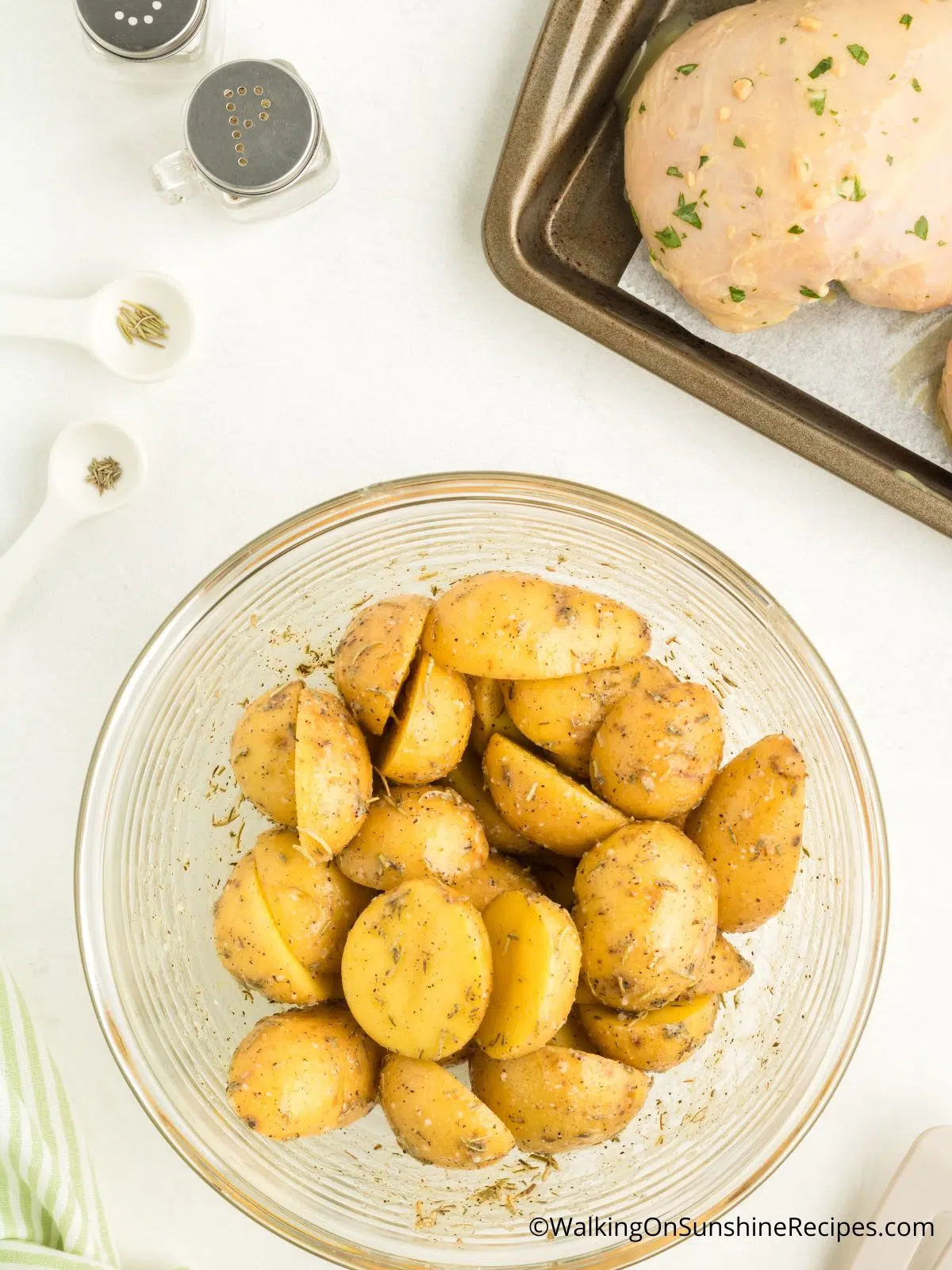 Yukon gold potatoes with seasoning in bowl.