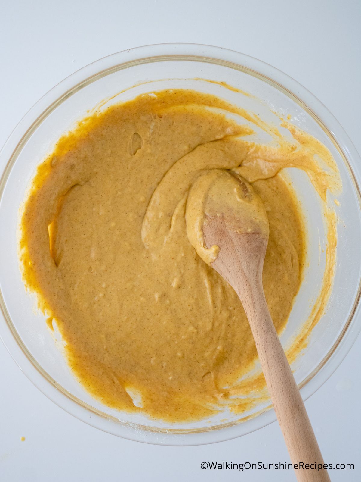 pumpkin pancake batter in a mixing bowl with a wooden spoon
