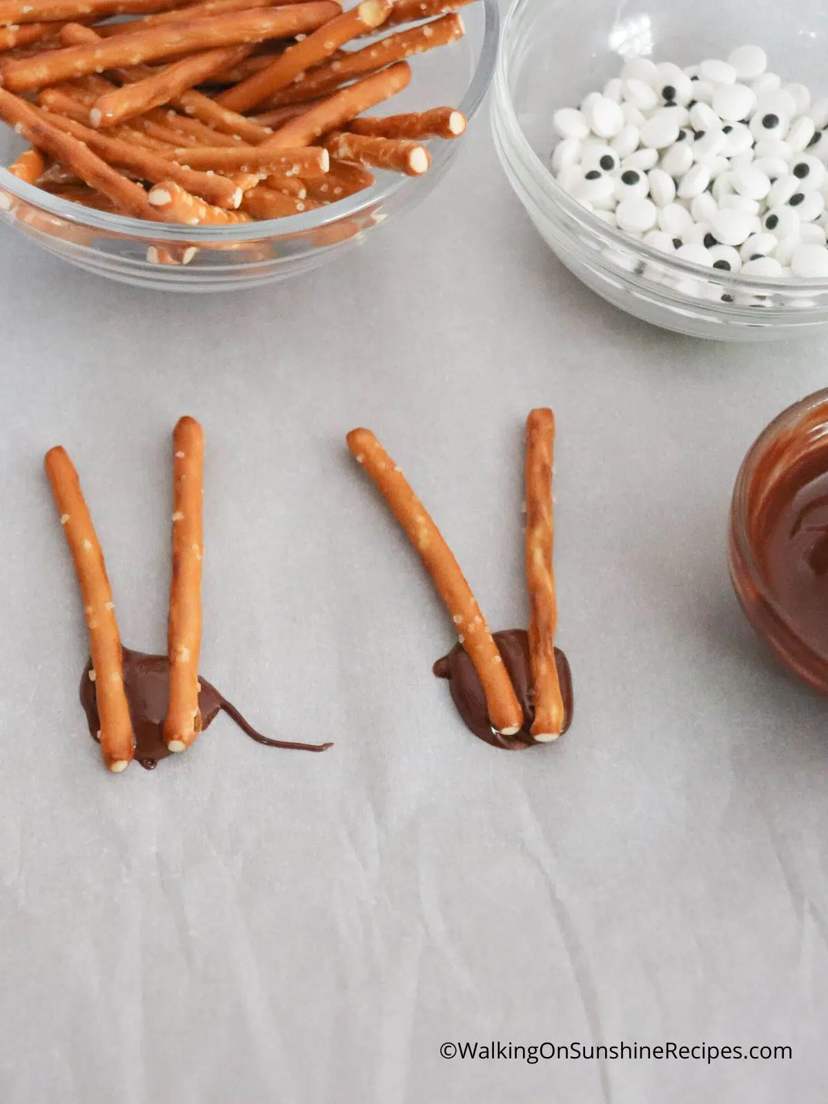 melted chocolate, pretzel sticks and candy eyes for candy reindeer treats.