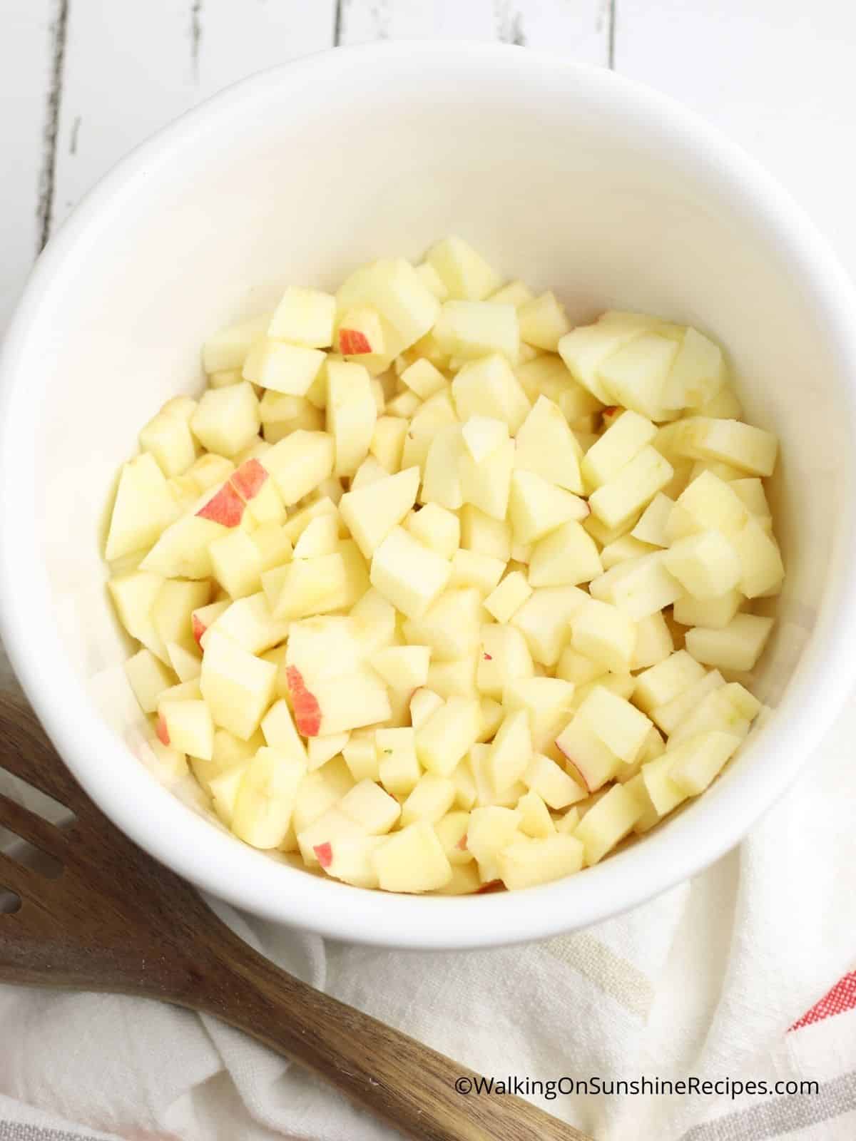 chopped apples in white bowl.