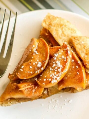 A slice of apple galette on a white plate.