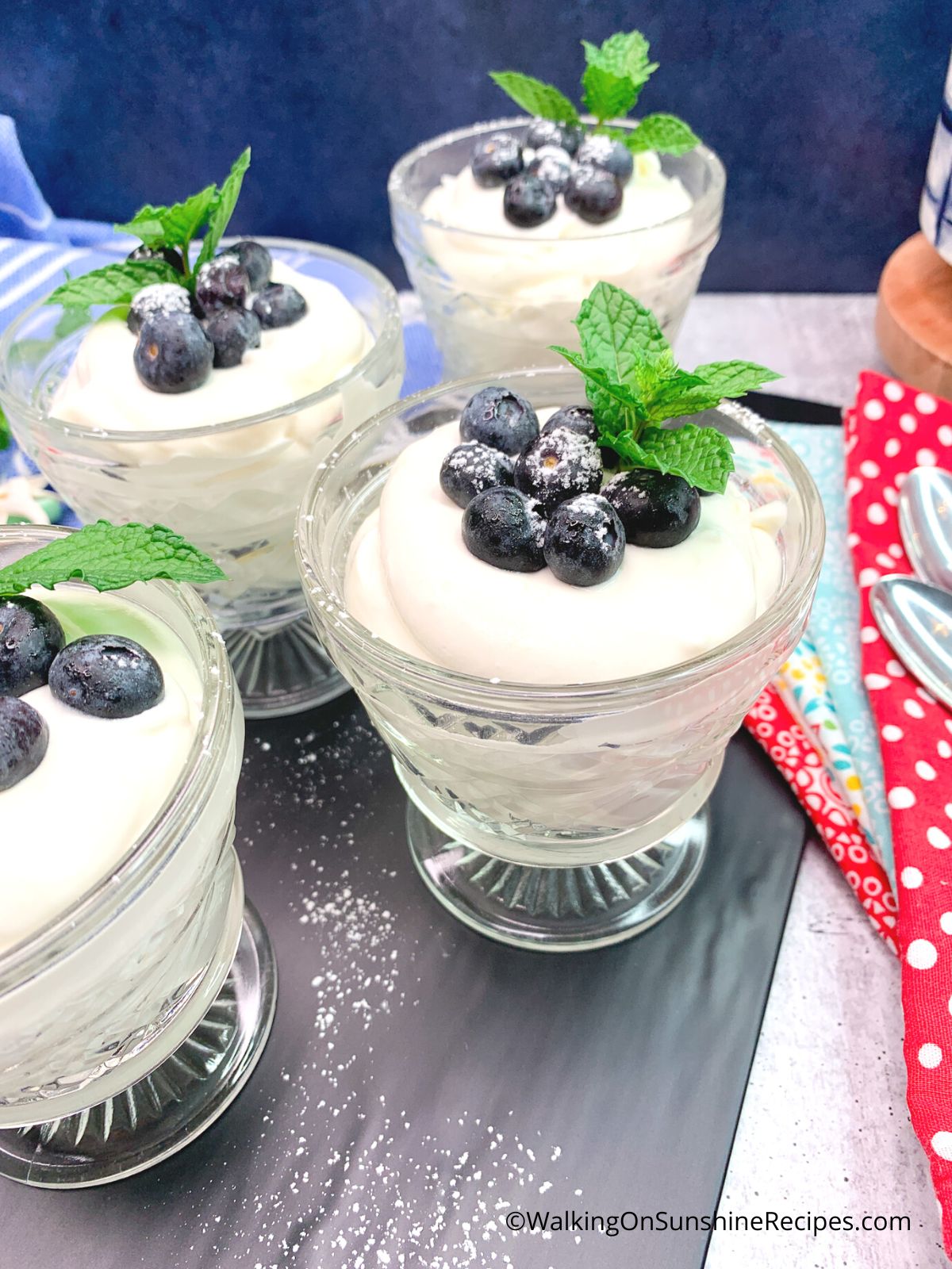 Serving cheesecake pudding in glass pudding cups with fresh berries and mint.