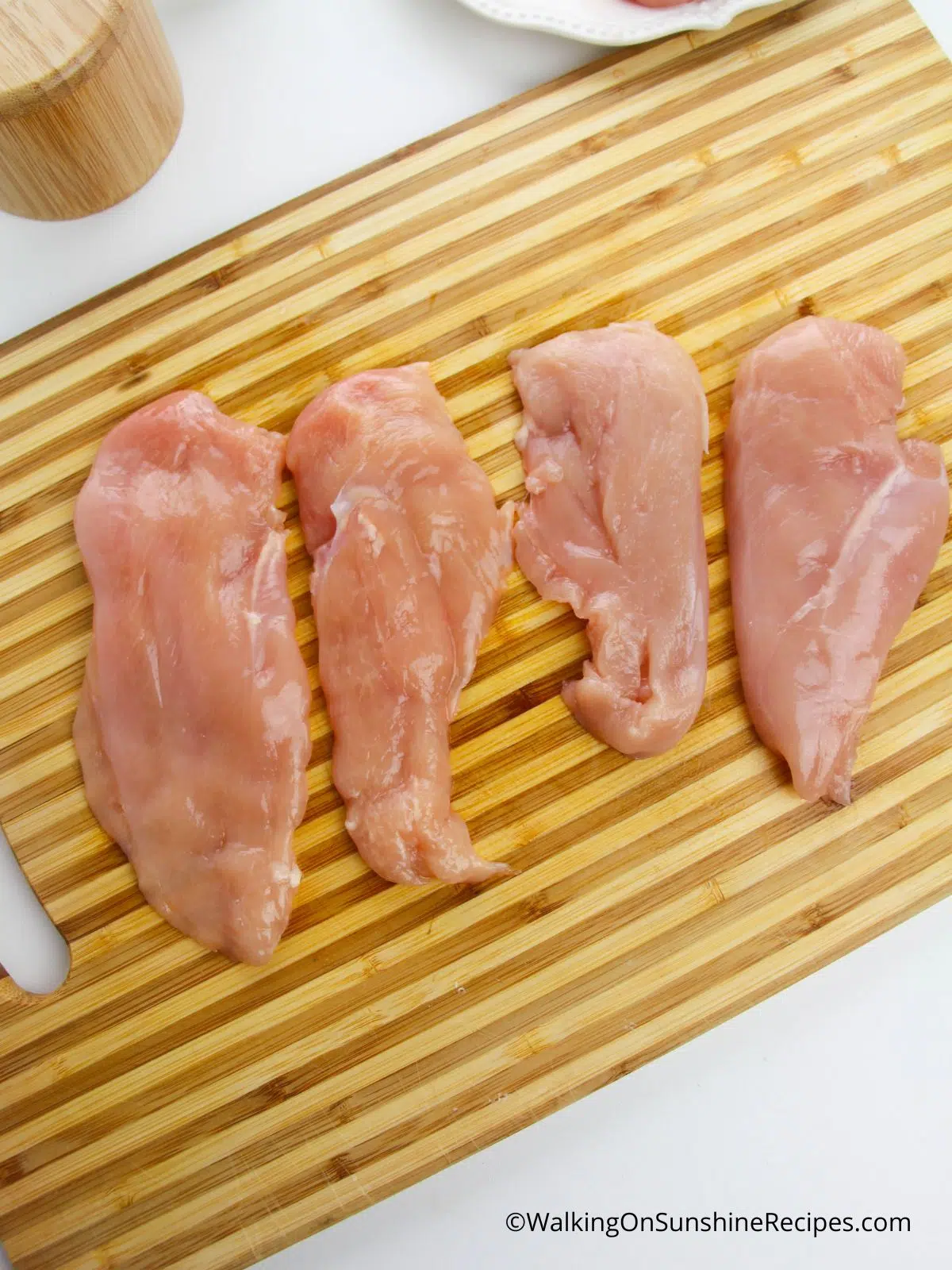 chicken cutlet on cutting board.