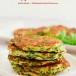stacked zucchini fritters on white plate.