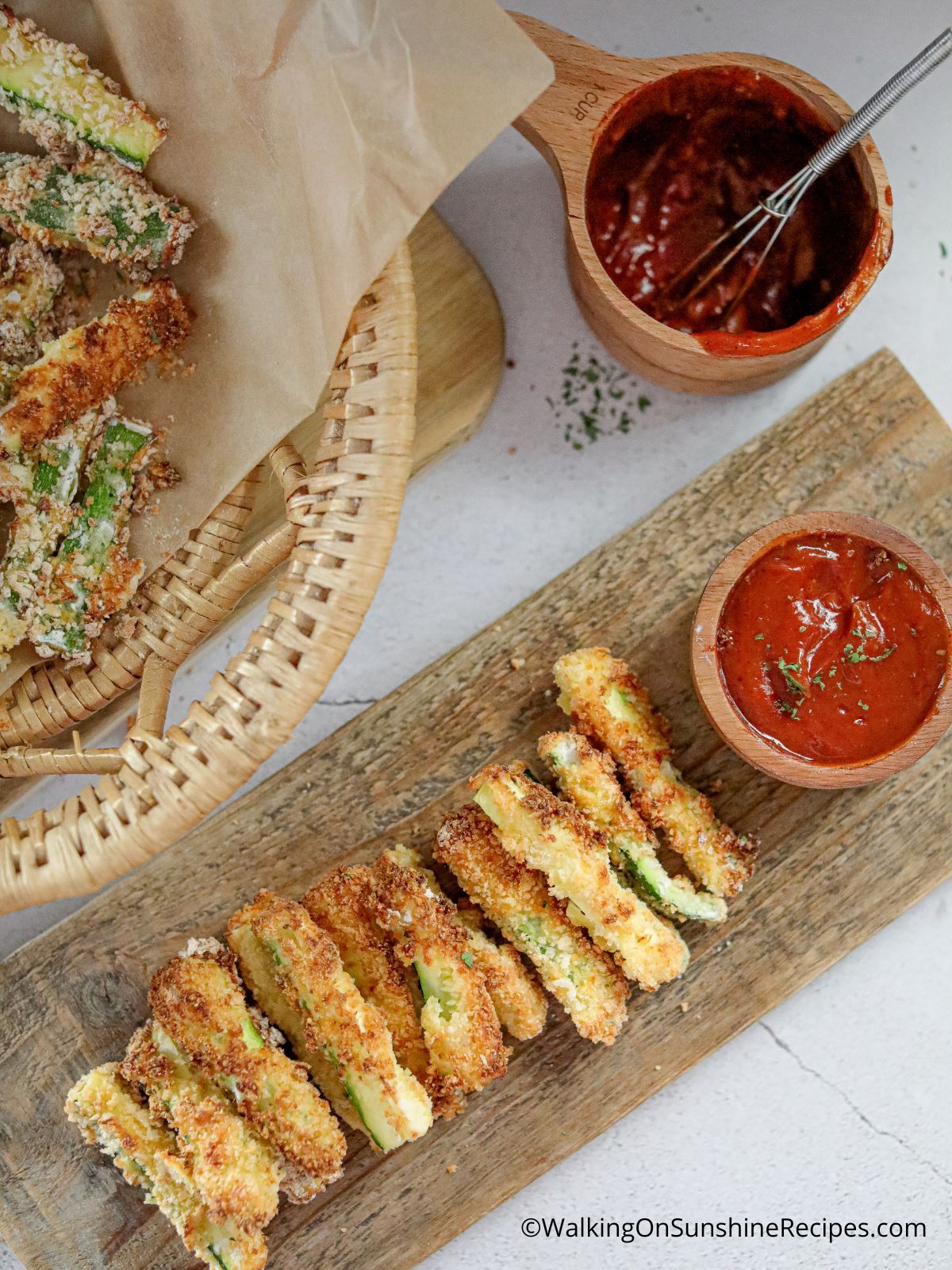Zucchini Fries on a wooden rectangle platter served with a small bowl of ketchup