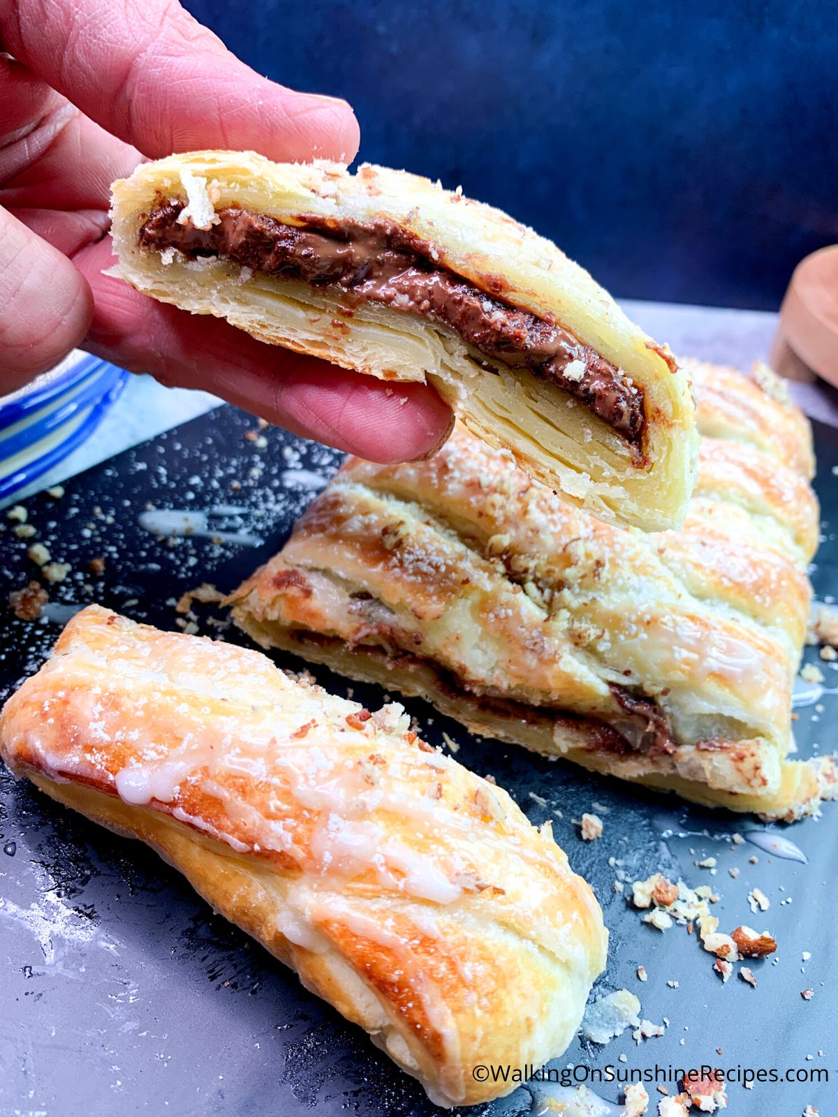 Closeup of chocolate puff pastry sliced and held in hand.