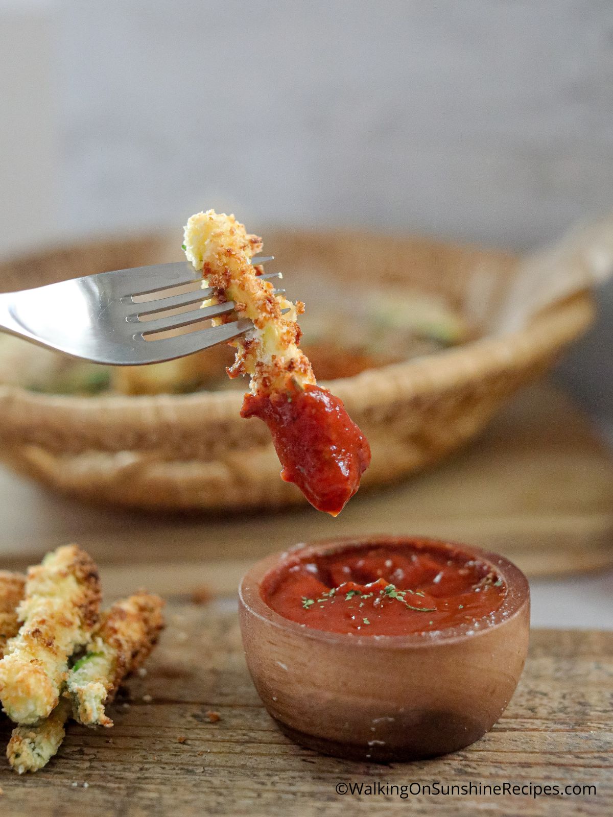 air fried zucchini fry on a fork with ketchup