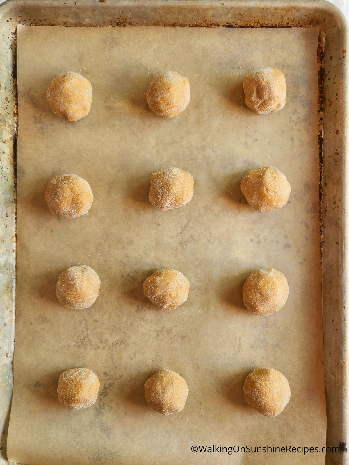 cookie dough balls on parchment paper tray.
