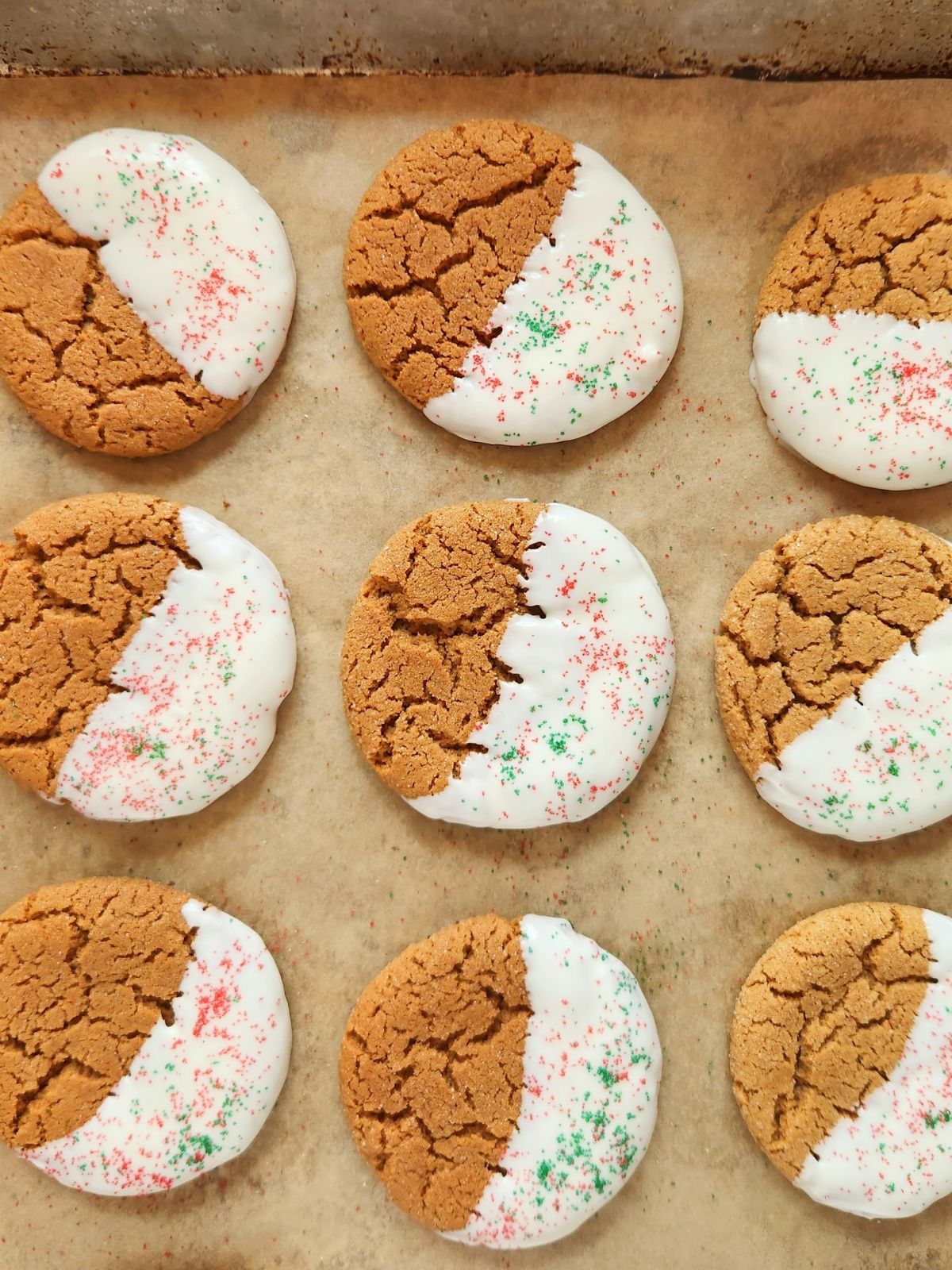 Iced Gingerbread Cookies on baking tray with parchment paper.