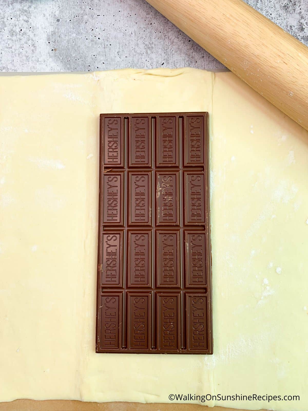 sheet of puff pastry with Hershey chocolate bar on top.