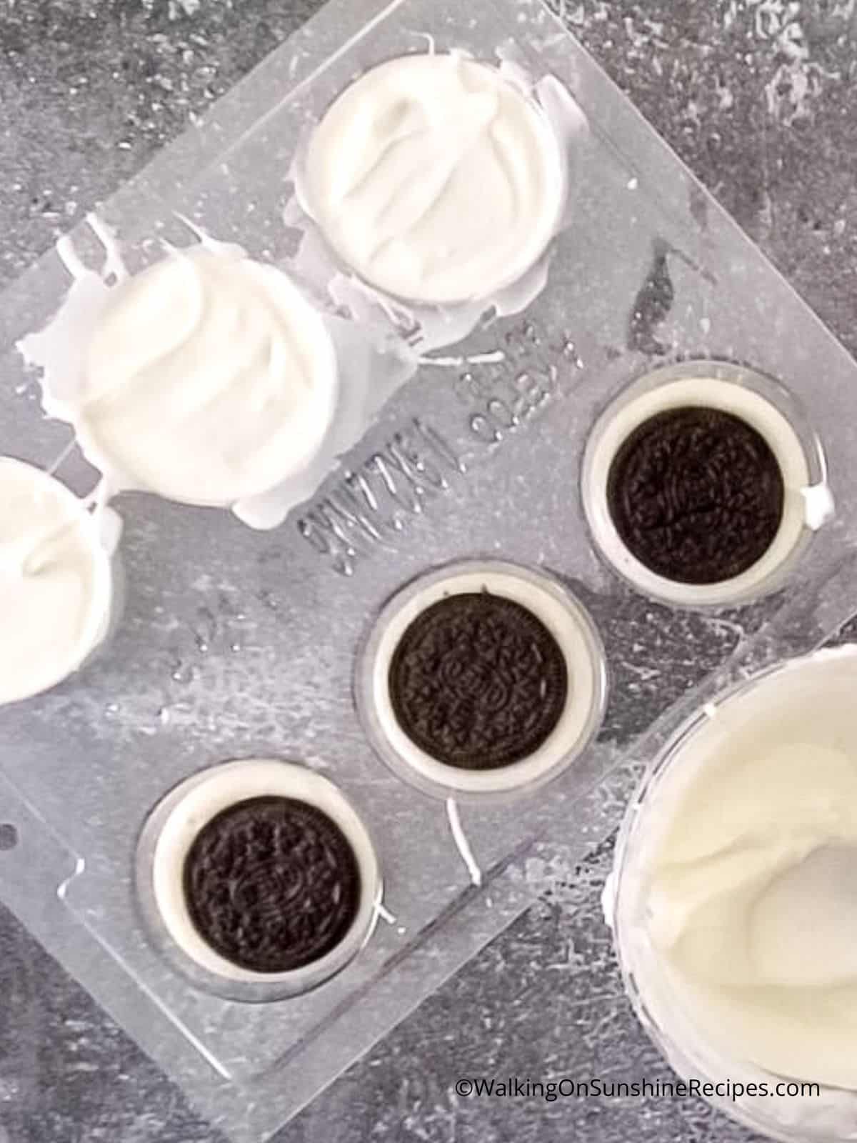 Oreo cookies in mold with melted white chocolate.